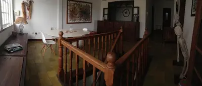 a room with a wooden staircase and a table and a table and a tableearcher at Casa Café Mindelo in Mindelo