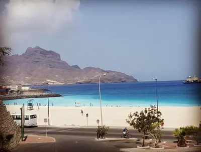 a beach with people on the sand and the water at Casa Café Mindelo in Mindelo