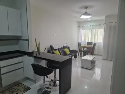 a kitchen and living room with a table and chairs at SUITES-HOME, CIDADELA in Praia