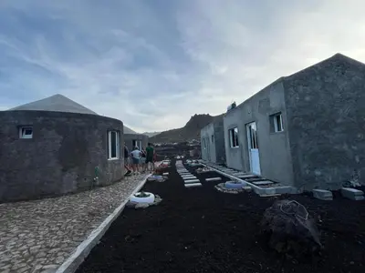 a group of people standing next to two buildings at Casa Adriano & Filomena in Portela