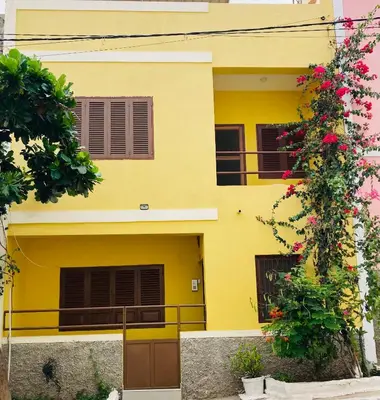 a yellow house with flowers in front of it at Constança Retreat in Mindelo