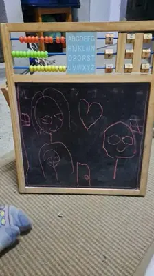 a chalk board with a drawing of people on it at Mendes Family Homestay - B&B In The Heart Of Praia in Praia