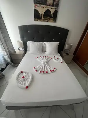 a white bed with red decorations on it at Residencial Santo Amaro in Tarrafal