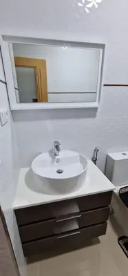 a bathroom with a white sink and a mirror at SUITES-HOME, CIDADELA in Praia