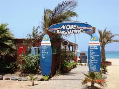 a couple of signs on the beach with a surfboard at Casa Bahia 8 in Santa Maria