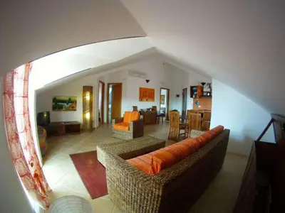 a living room with a couch and a dining room at Casa Bahia 10 Grande Penthouse in Santa Maria