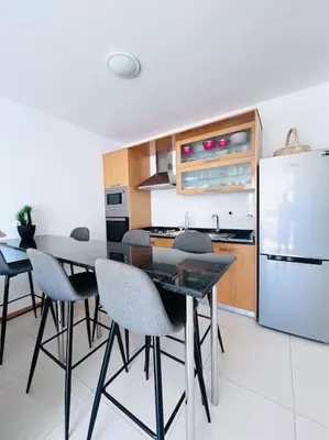 a kitchen with a table and chairs and a refrigerator at Bliss Apartments T1 - Adélia in Mindelo