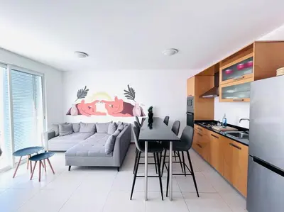 a kitchen and living room with a couch and a table at Bliss Apartments T1 - Adélia in Mindelo