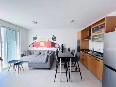 a kitchen and living room with a couch and a table at Bliss Apartments T1 - Adélia in Mindelo