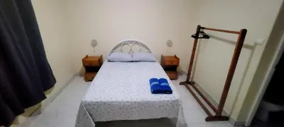 a bedroom with a bed with blue slippers on it at OpenSky in São Filipe