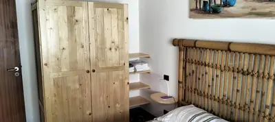 a bedroom with a wooden cabinet next to a bed at Apartamento Porto Antigo 2 in Santa Maria
