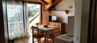 a dining room with a table and a television at Apartamento Porto Antigo 2 in Santa Maria
