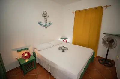 a bedroom with a bed with a cross on the wall at Appartamento LULA. Stella Maris Exclusive in Calheta Do Maio