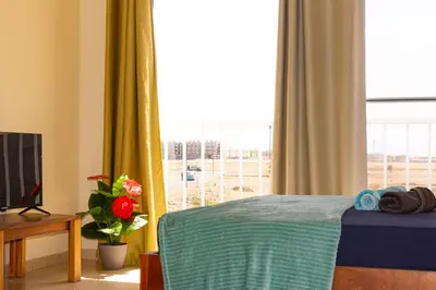 a bedroom with a bed and a large window at Beauty Plaza Suites in Santa Maria