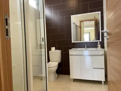 a bathroom with a toilet and a sink and a mirror at Beauty Plaza Suites in Santa Maria