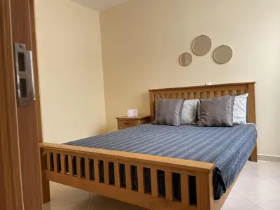a bedroom with a wooden bed with a blue comforter at Beauty Plaza Suites in Santa Maria