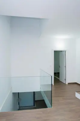 a glass stair case in a room with a hallway at Villa Santiago in Praia
