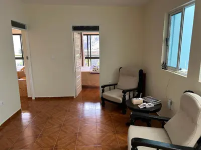 a living room with two chairs and a table at Casa Manuel & Elvira in Chão Queimado