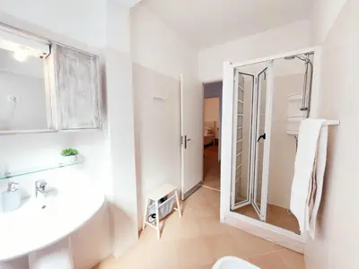 a bathroom with a shower and a sink and a mirror at Branco Sea Holiday Apartments in Santa Maria