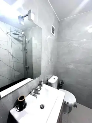 a white bathroom with a sink and a toilet at Bliss Apartments T3 - Zita - On The Beach in Mindelo