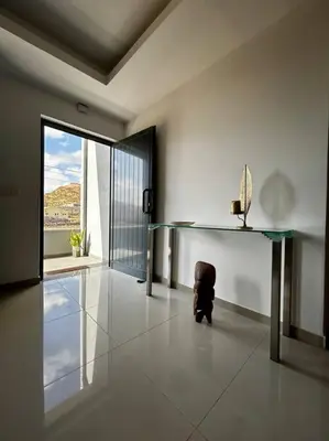 a room with a glass table and a person sitting on the floor at Modern Apartment in Praia Baixo - 1 min Walking to Beach in Praia Baixo