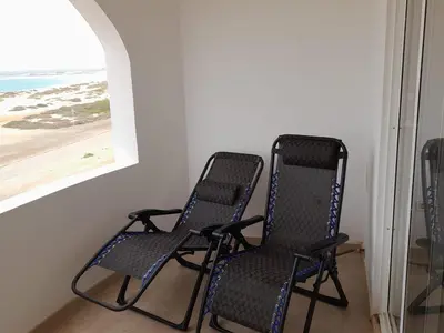 two chairs in a room with a view of the beach at Pandora Ocean View am Praia Cabral in Sal Rei