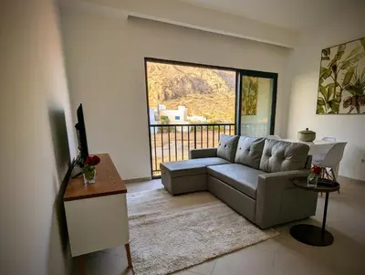 a living room with a couch and a large window at Tarrafal Bay - 1Bdr Apt - Sea view - 2 in Tarrafal
