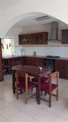 a kitchen with a wooden table and two chairs at Casa Sofia in Mindelo