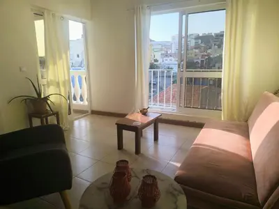 a living room with a couch and a large window at Casa Sofia in Mindelo