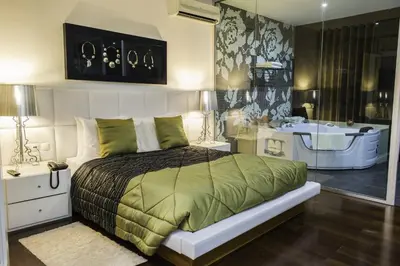 a bedroom with a bed and a bathroom with a tub at Hotel Vip Praia in Praia