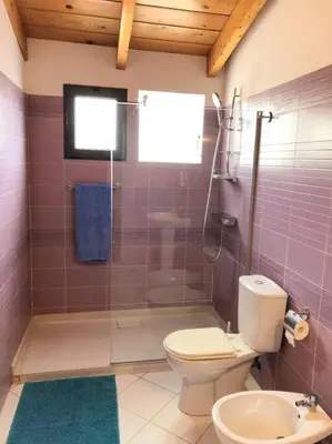 a bathroom with a toilet and a glass shower at Penthouse with Panoramic Ocean Views and unlimited WiFi in Santa Maria