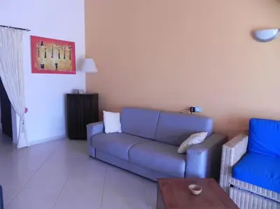 a living room with a blue couch and a table at Penthouse with Panoramic Ocean Views and unlimited WiFi in Santa Maria