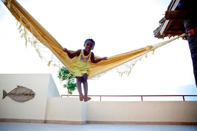 a girl is sitting in a hammock at Casa Strela B&B Tarrafal in Tarrafal