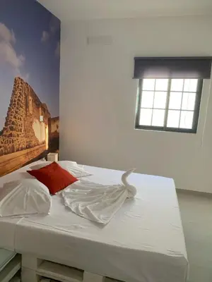 a bedroom with a bed with a painting on the wall at Palmira House in Cidade Velha