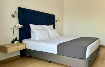 a bedroom with a large bed with a blue headboard at Hôtel Blue Sky in Tarrafal