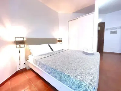 a white bedroom with a bed with a lamp on it at Calma de Sal Porto Antigo II Beach apartment in Santa Maria