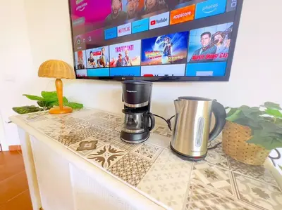 a coffee maker sitting on a table with a tv at Calma de Sal Porto Antigo II Beach apartment in Santa Maria