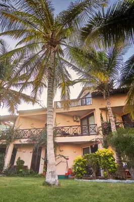 a building with two palm trees in front of it at Calma de Sal Porto Antigo II Beach apartment in Santa Maria