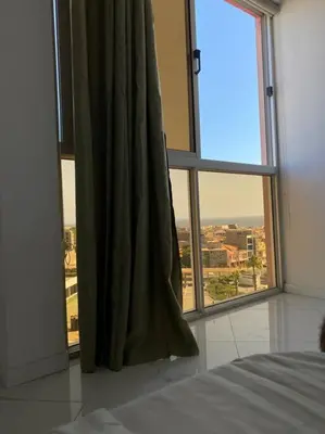 a bedroom with a large window with a view of a city at Apartamento sublime c/vista top. in Praia