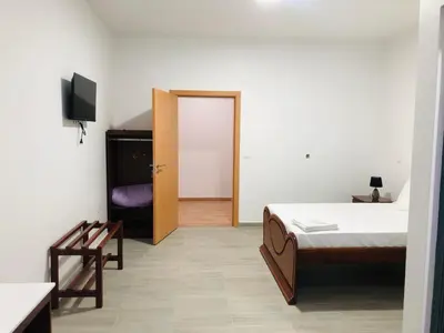 a bedroom with a bed and a door with a television at COSEC Tours in Cova Figueira