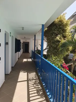 a corridor of a hospital with a blue fence and plants at Holiday Properties Leme Bedje in Santa Maria