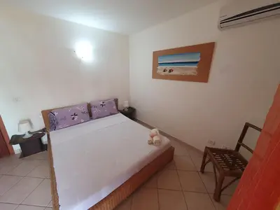 a bedroom with a bed and a picture of a beach at Holiday Properties Leme Bedje in Santa Maria