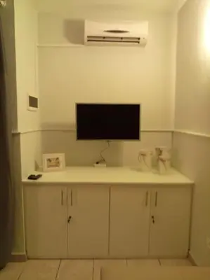 a room with a tv on top of a cabinet at Apartamento Djadsal Moradias L01 próximo à praia in Santa Maria