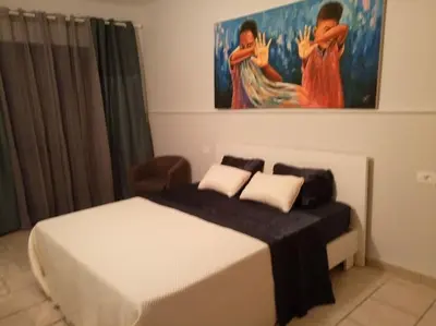 a bedroom with a bed and a painting on the wall at Apartamento Djadsal Moradias L01 próximo à praia in Santa Maria