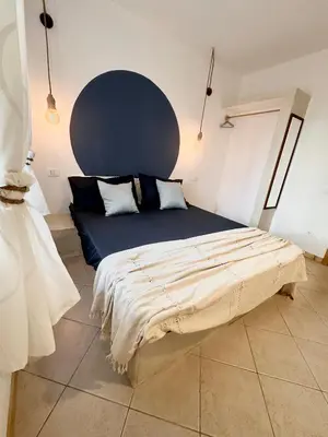 a bedroom with a bed with a blue head board at Boutique Apartments Ibiscus in Santa Maria