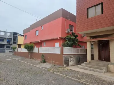 a red building with stairs next to a street at Jbct & SOLANGE APART in Praia