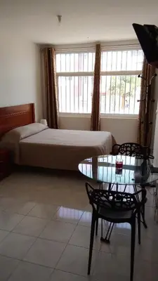 a bedroom with a bed and a table with a glass table sidx sidx at Estúdio Vieira in Praia
