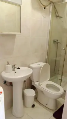a bathroom with a toilet and a sink and a shower at Estúdio Vieira in Praia