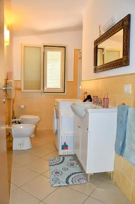 a bathroom with a sink and a toilet and a mirror at Kyaala Djadsal Moradias pool&sea in Santa Maria