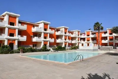 an apartment complex with a swimming pool in front of a building at Kyaala Djadsal Moradias pool&sea in Santa Maria